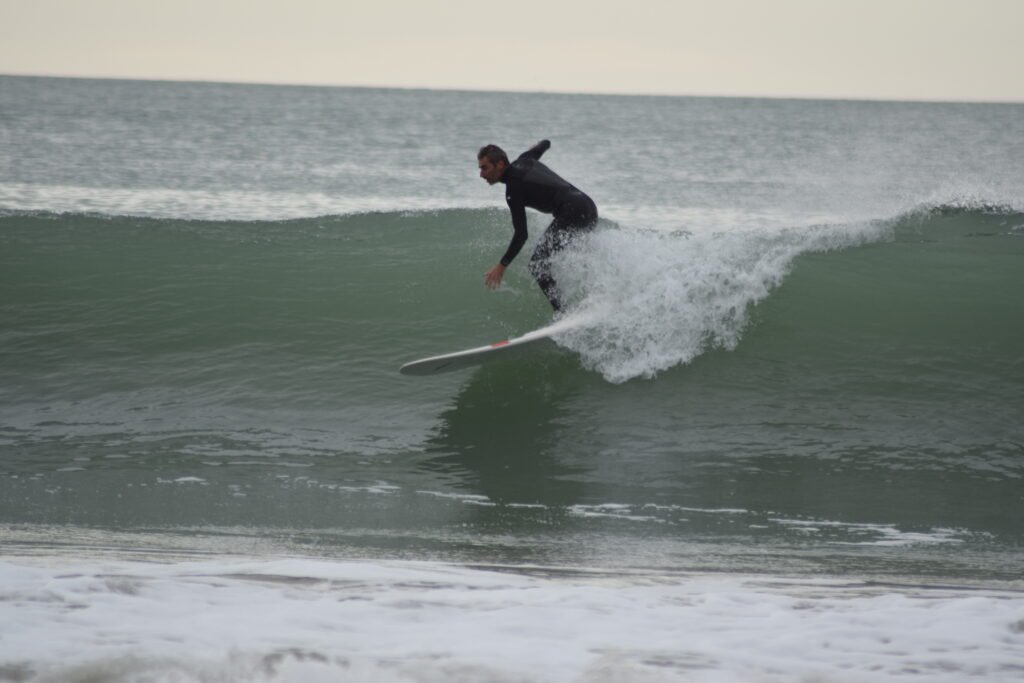 Photo d'un surfeur sur une vague d'environ un mètre dix